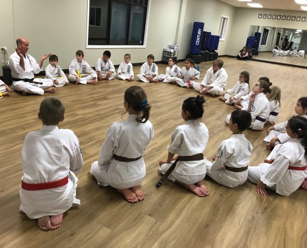 Kids sitting in a circle at Neil Stone's Karate Academy